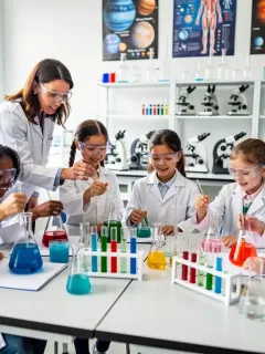 Children conducting science experiment in modern classroom, representing STEM education and grants.